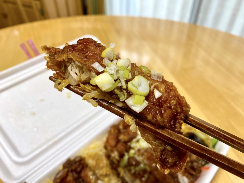 大阪王将浜田山店のスーパーノリ弁当の油淋鶏を食べるところ
