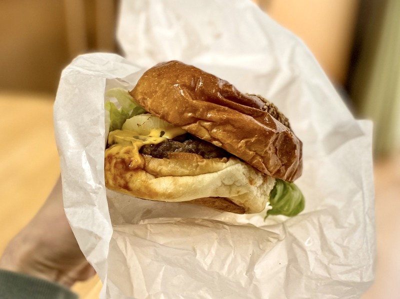 .Kurodo's Burgerのプレミアムチーズバーガーを食べるところ