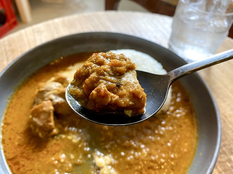 永福町の22CAFEのスパイスチキンカレーのチキンを食べるところ